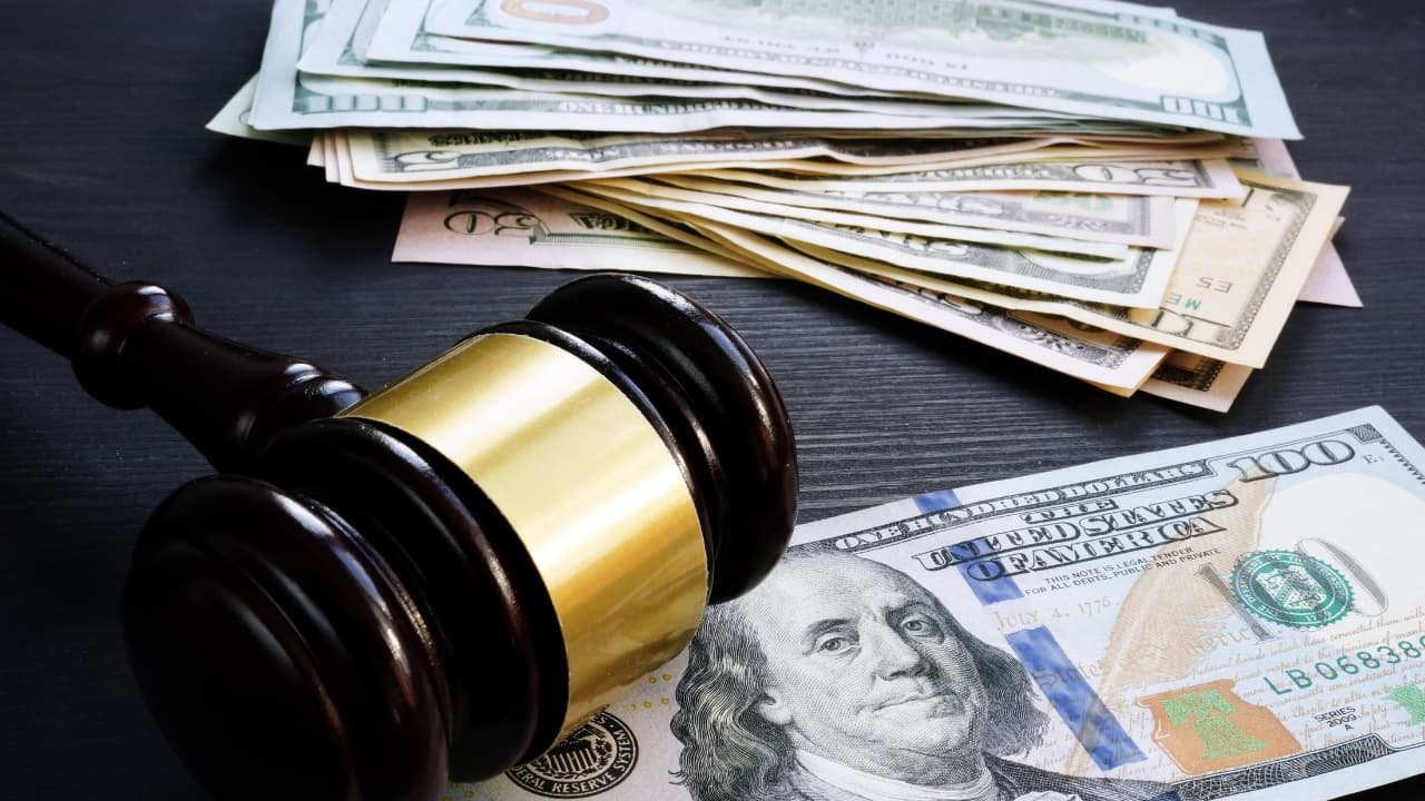 judges gavel and stack of hundred dollar bills for legal Repercussions and Penalties for FLSA Violations