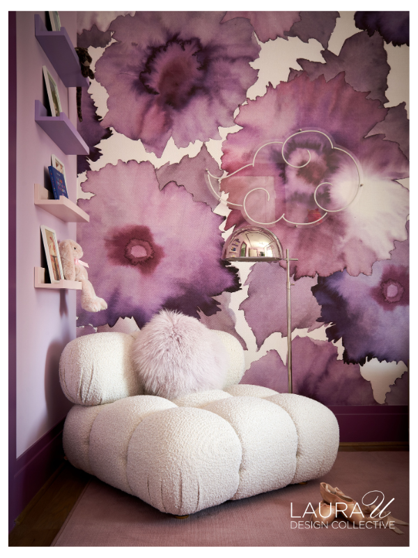 Girls' bedroom designed by Laura U Design Collective featuring Phillip Jeffries Bloom mural wallcovering in Fuchsia on Japanese Paper Weave, oversized watercolor floral wallpaper, lavender walls, boucle lounge chair, and contemporary acrylic floor lamp.