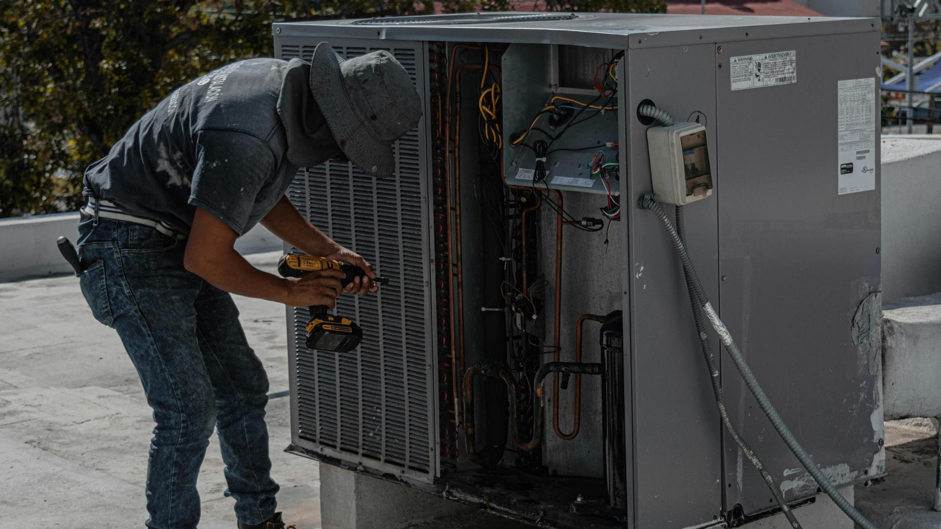 HVAC technician repairing a commercial rooftop air conditioning unit