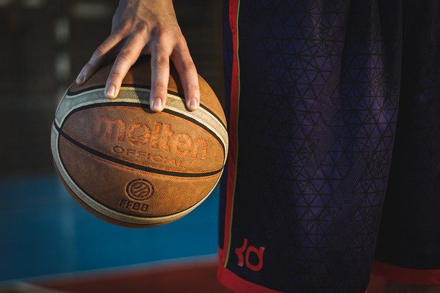 basketball player palming a Molten brand basketball