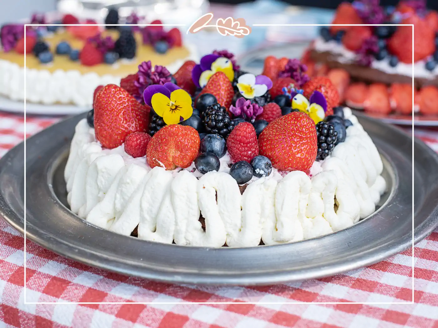 Fruit and berry cake decorated with whipped cream and edible flowers. Fabulous Flowers and Gifts.
