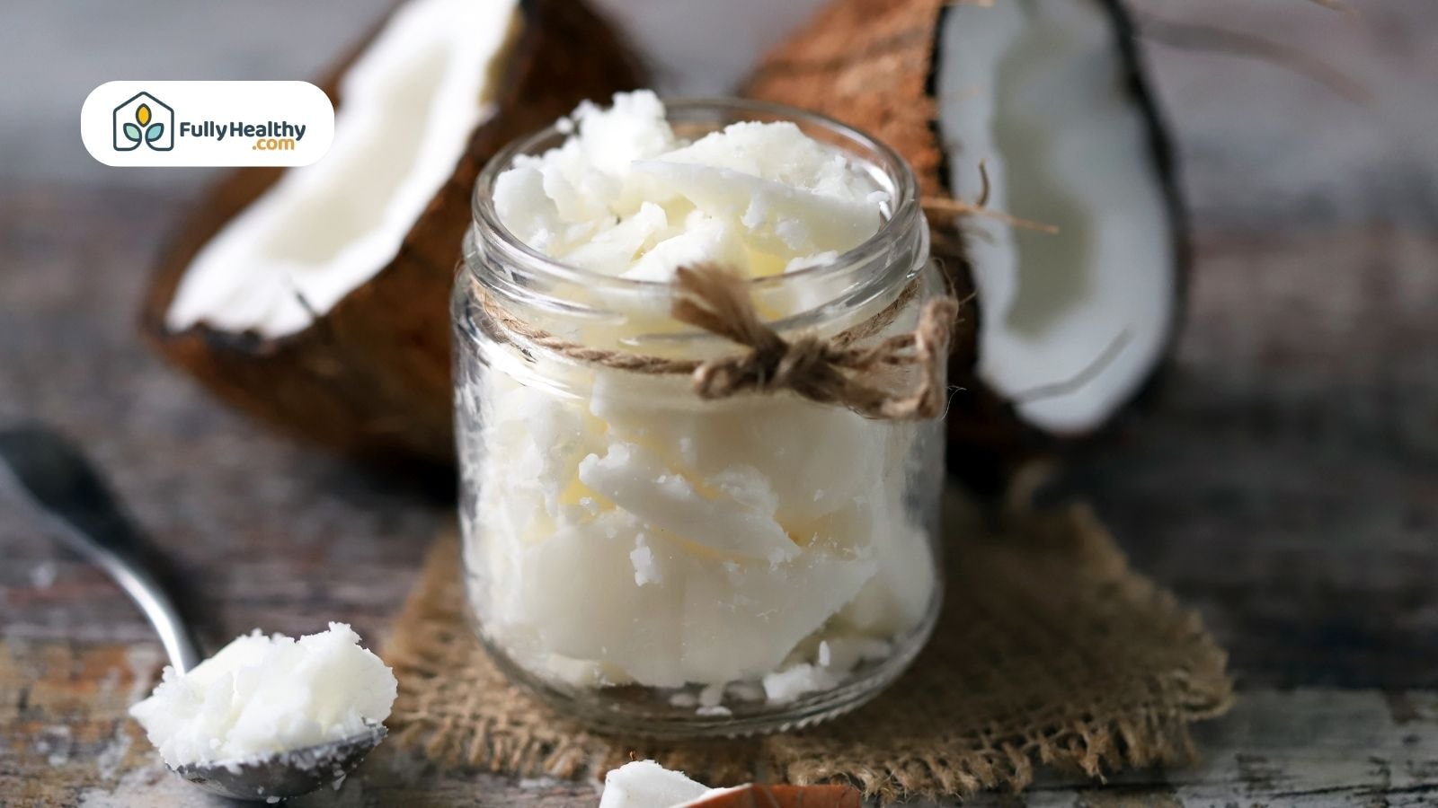 Jar of solid coconut oil with coconuts at the back