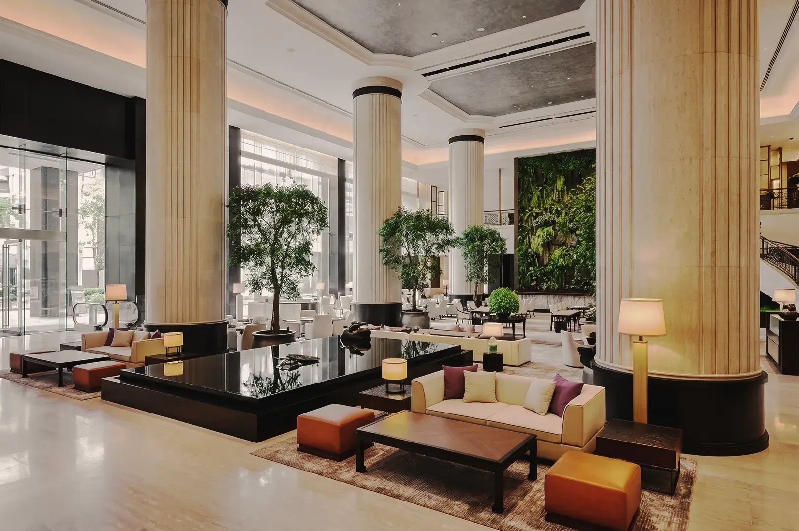 Elegant hotel atrium featuring dramatic contemporary sculpture, glass ceiling, and sophisticated luxury hospitality design