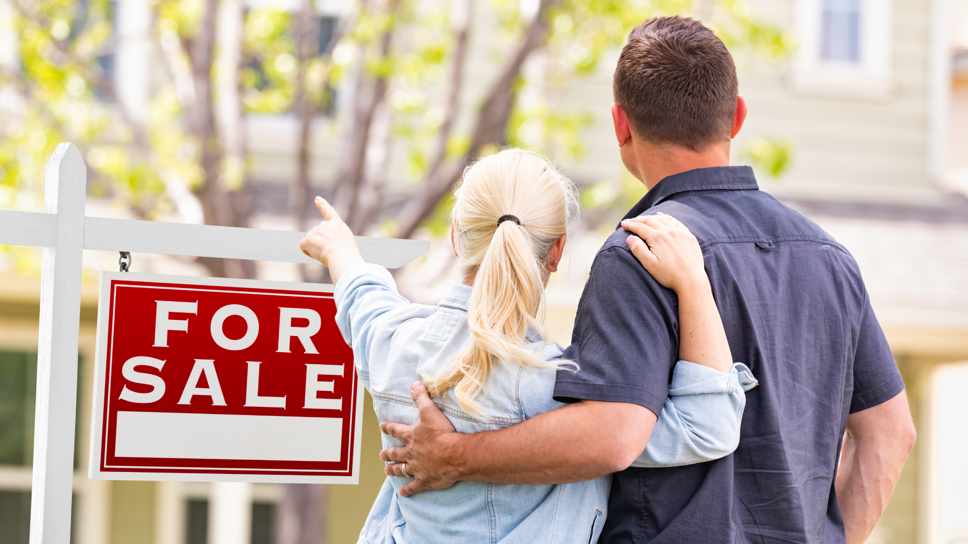homebuyers in front of a for sale sign
