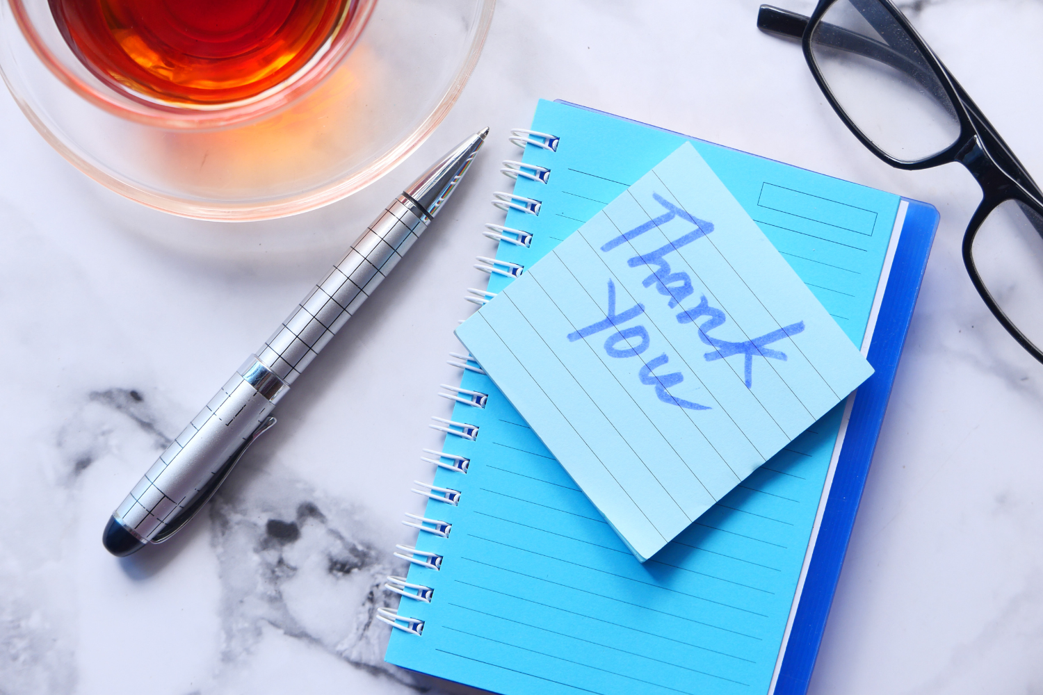 Thank you written on a sticky note.