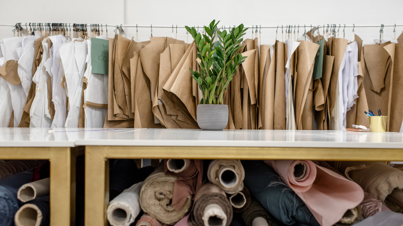 Several rolls of rayon and cotton fabrics are on display in a sewing room