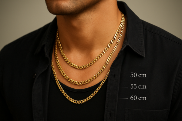 Jaunas vyras dėvi keturias skirtingo ilgio auksines grandinėles ant kaklo. Šalia jų pažymėti ilgiai centimetrais – 50 cm, 55 cm, 60 cm. Fone matomas juodas marškinėlių ir marškinių fragmentas