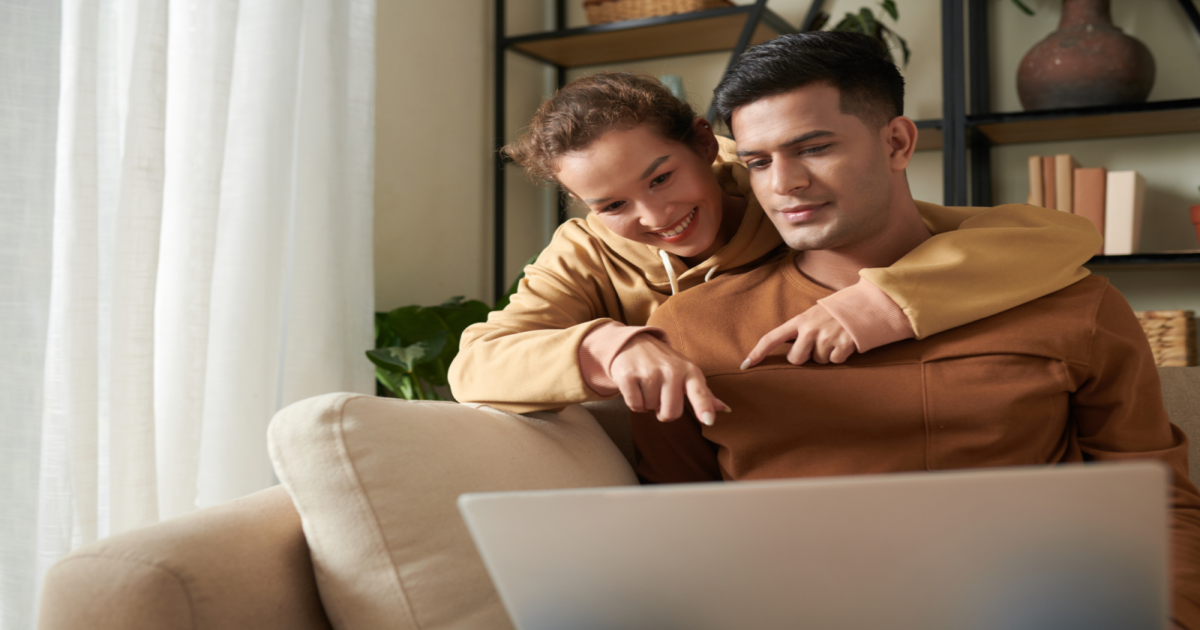 A photograph of a couple sitting in front of a computer screen with a licensed Gottman Method Couples Therapist visible through the video conferencing software. The couple appears engaged and attentive, possibly participating in an online couples therapy session. The image conveys the idea of a couple taking advantage of the convenience and accessibility of online couples therapy to seek help from a certified Gottman Method Couples Therapist in New York City. It suggests that online couples therapy can be just as effective as in-person sessions, providing couples with the tools and techniques needed to improve their communication, build emotional connection, and reduce conflict in their relationship.