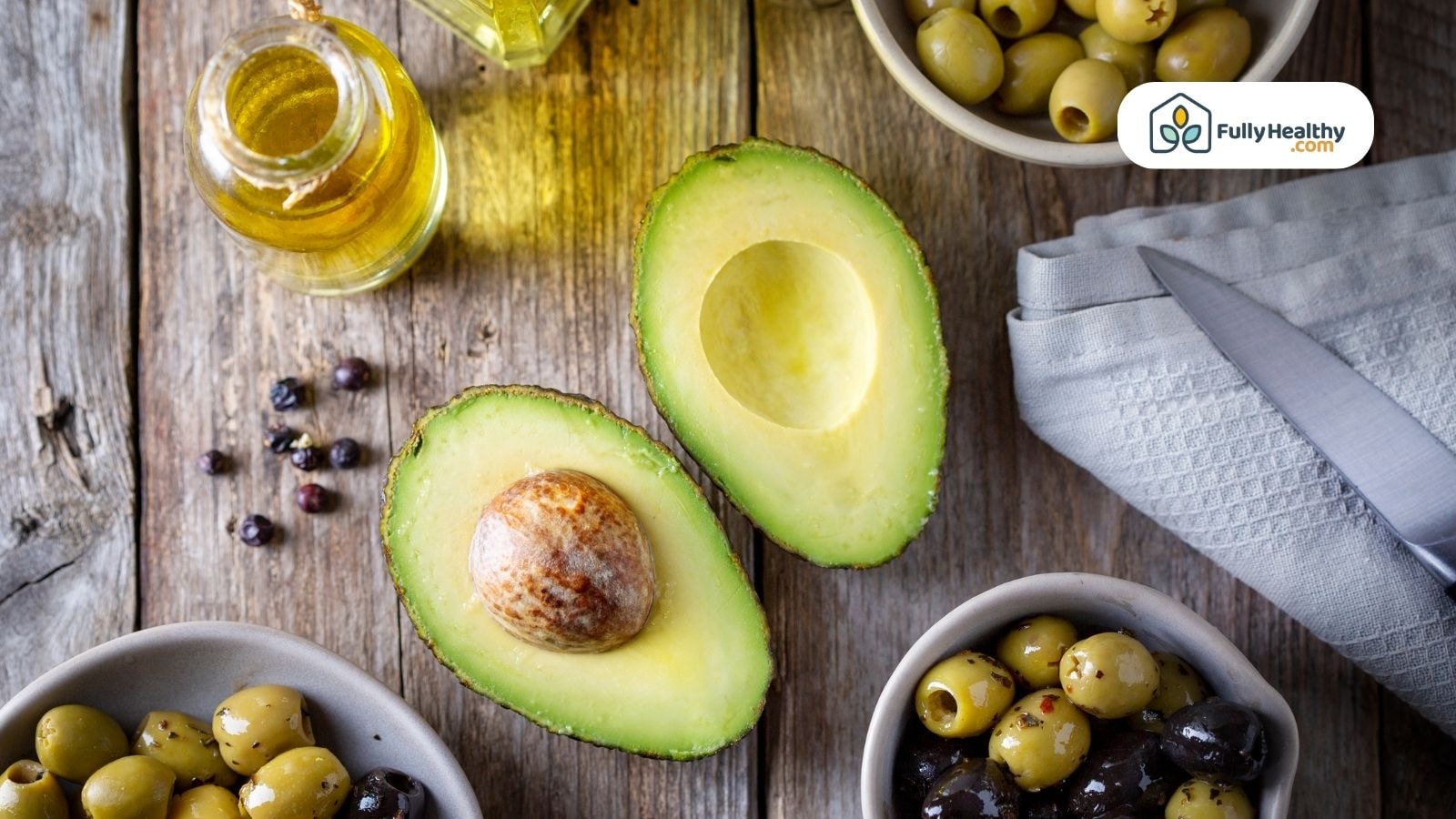 Fresh avocado halves with olives and golden olive oil.