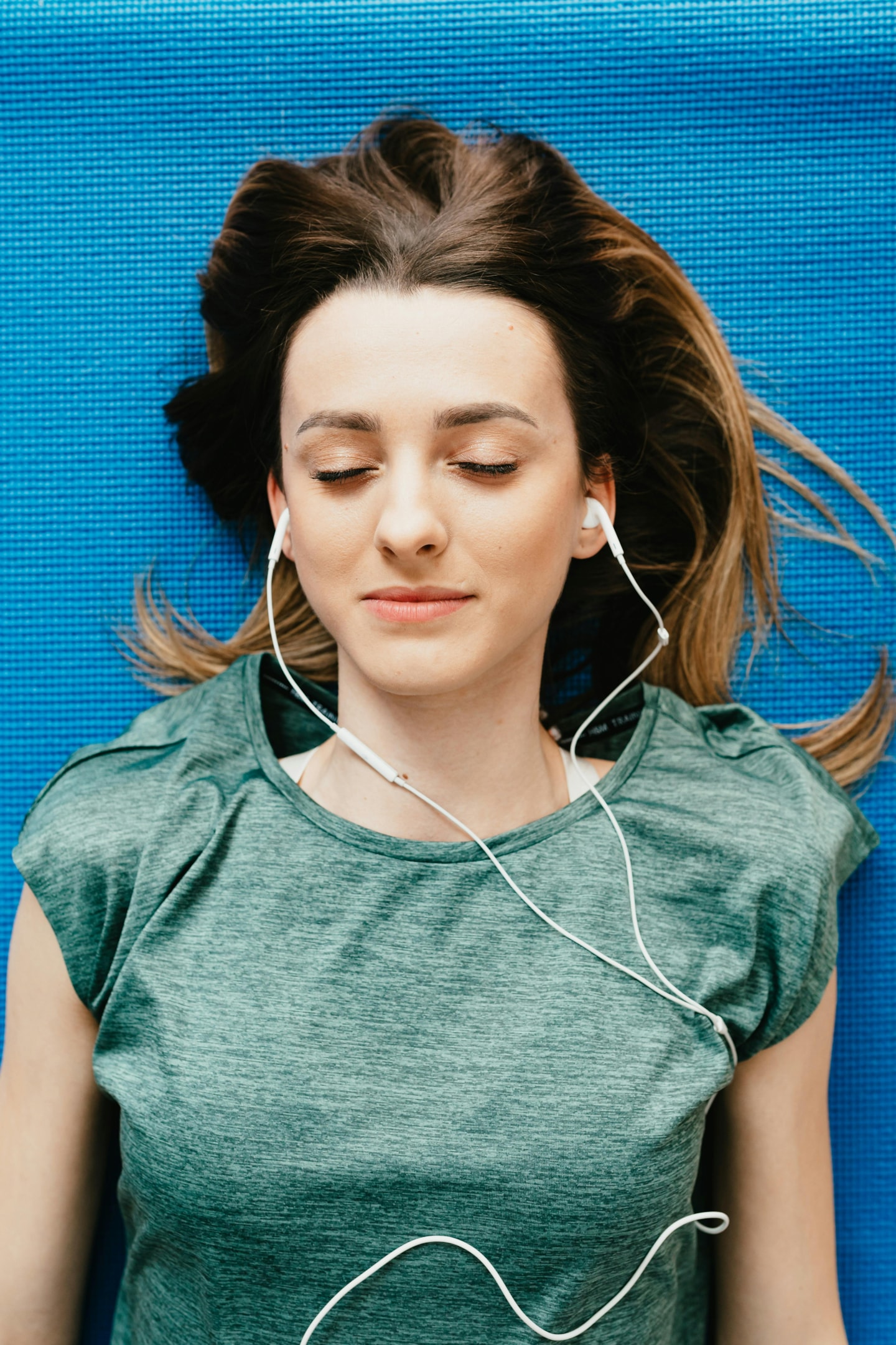 woman lying on her back with headphones on