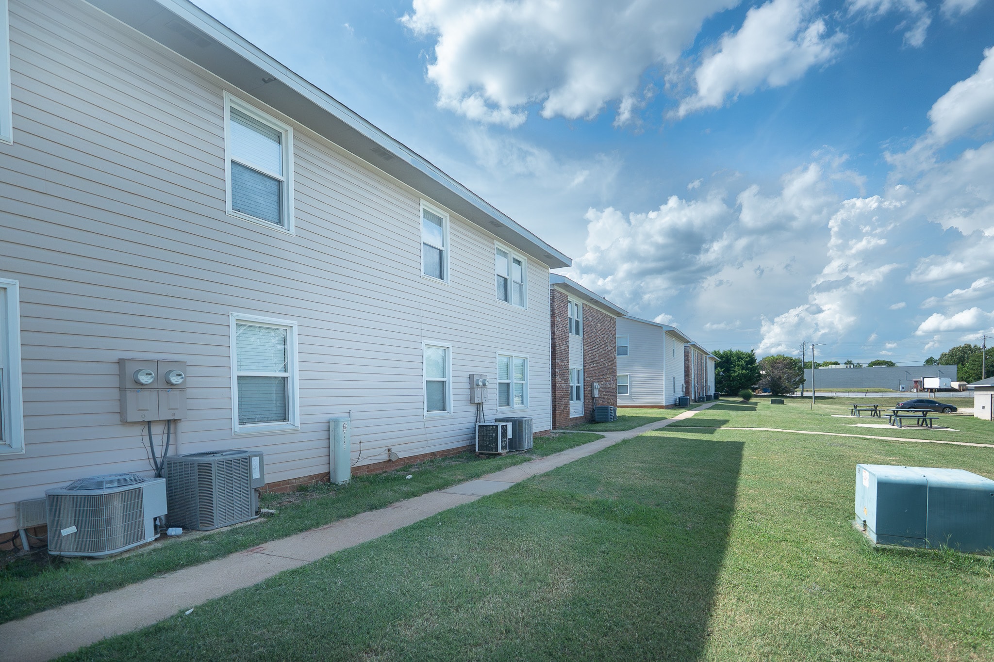 Exterior view of multifamily apartment buildings with green space and modern amenities, highlighting community-focused real estate investments and strong renter demand.