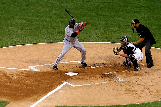 A person checking and maintaining a batter's box