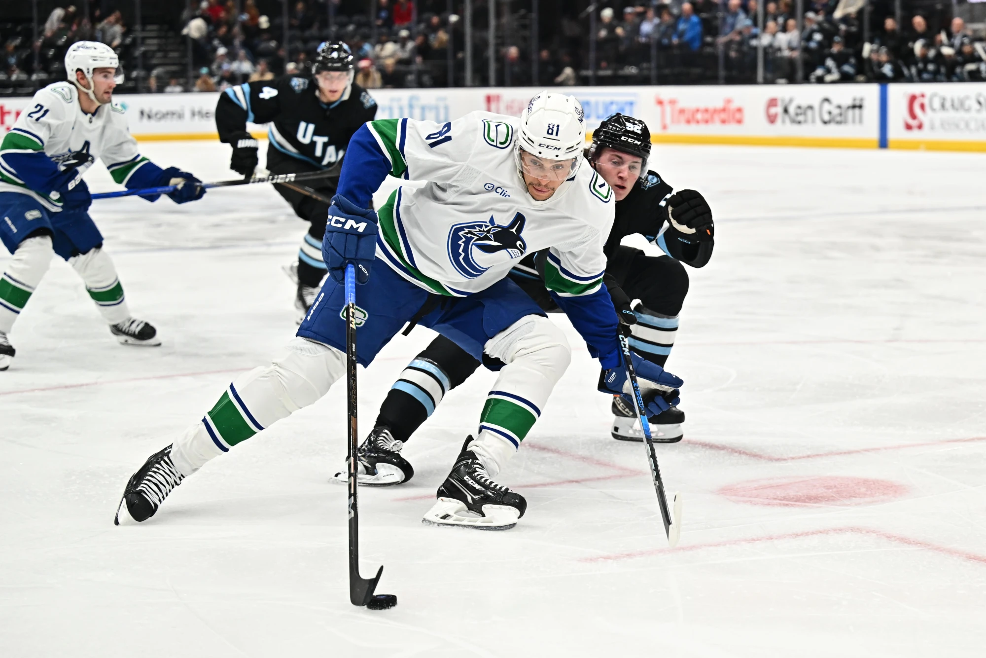 Dakota Joshua of the Vancouver Canucks shields the puck from Logan Cooley of the Utah Hockey Club during the second period of a game on December 18, 2024 at Delta Center in Salt Lake City, Utah