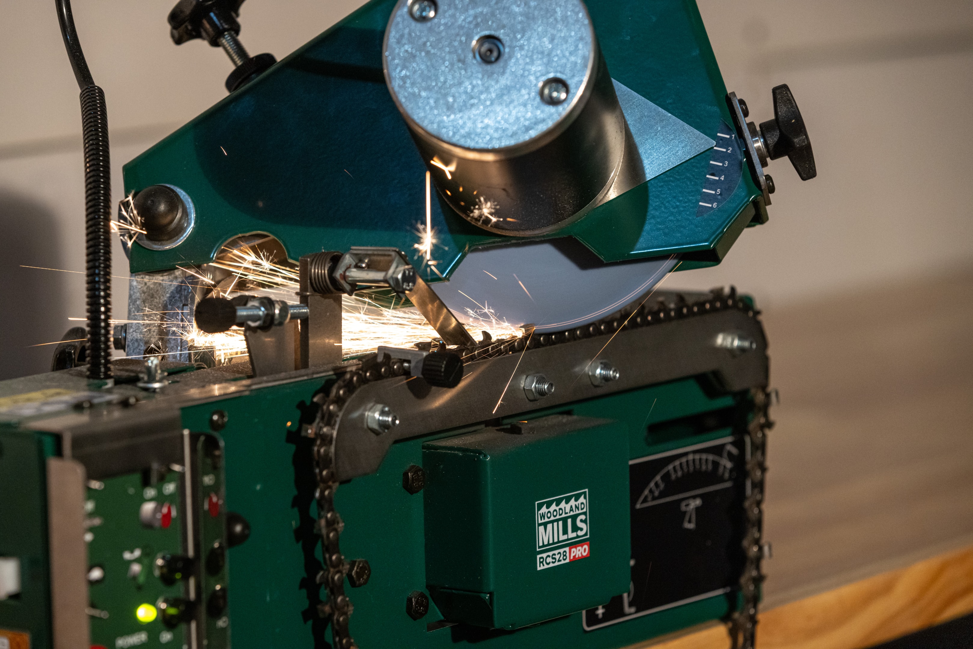 A Woodland Mills RCS28 Chainsaw Sharpener, using a depth guide to perfectly sharpen a chain. 