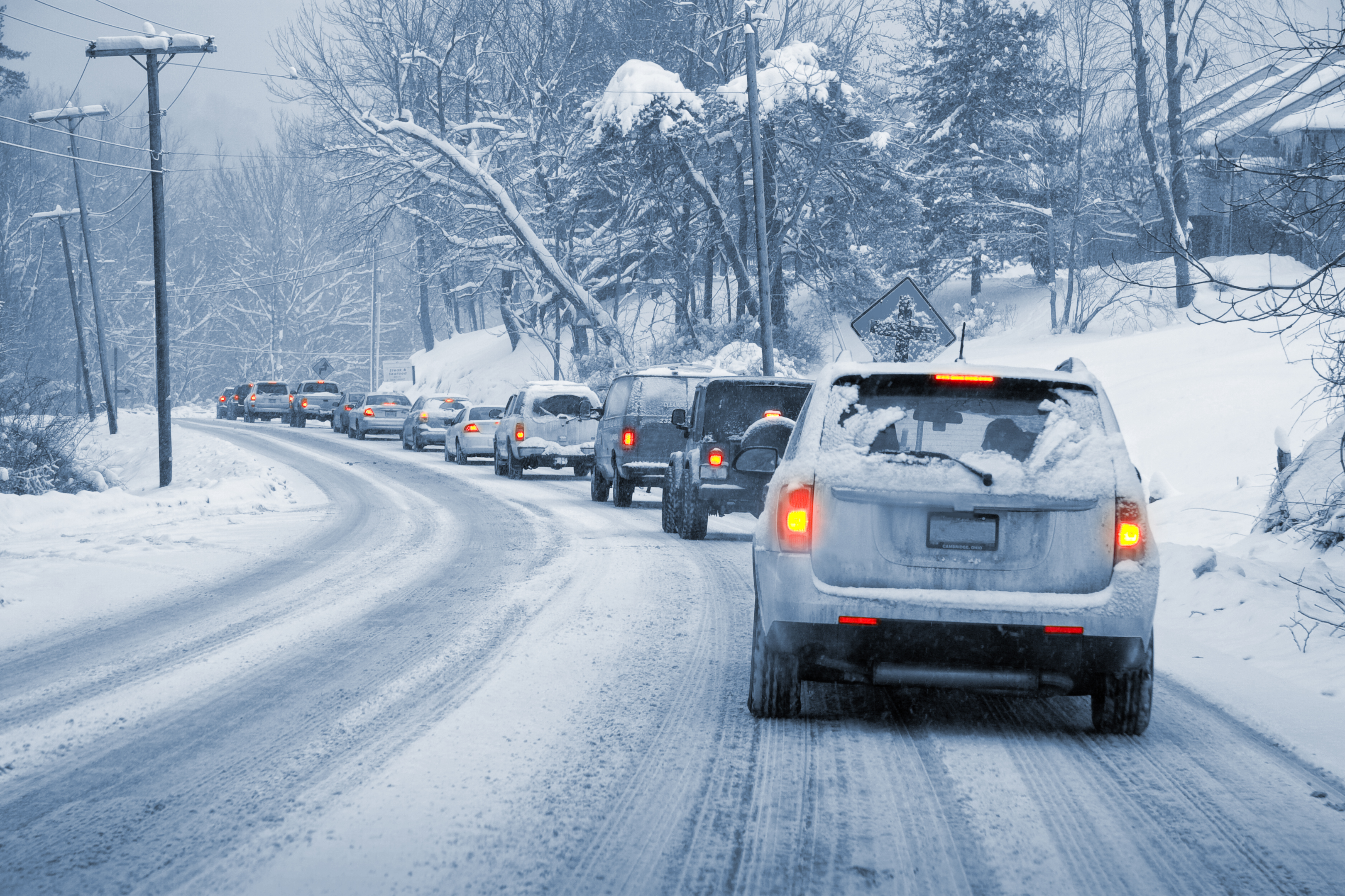 Cars driving on a slippery surface during a snow storm. 