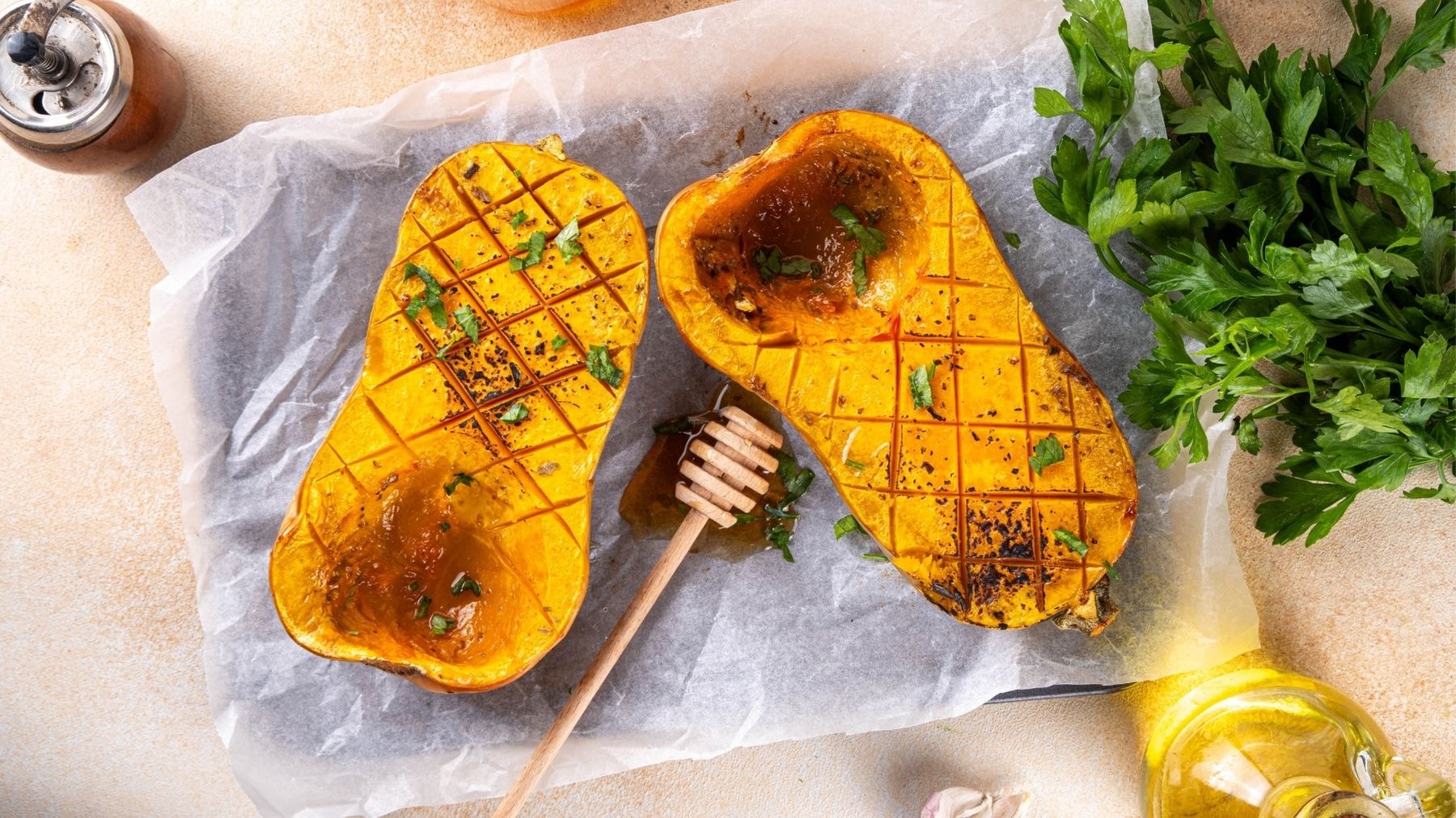 Roasted butternut squash halves drizzled with honey and garnished with fresh herbs