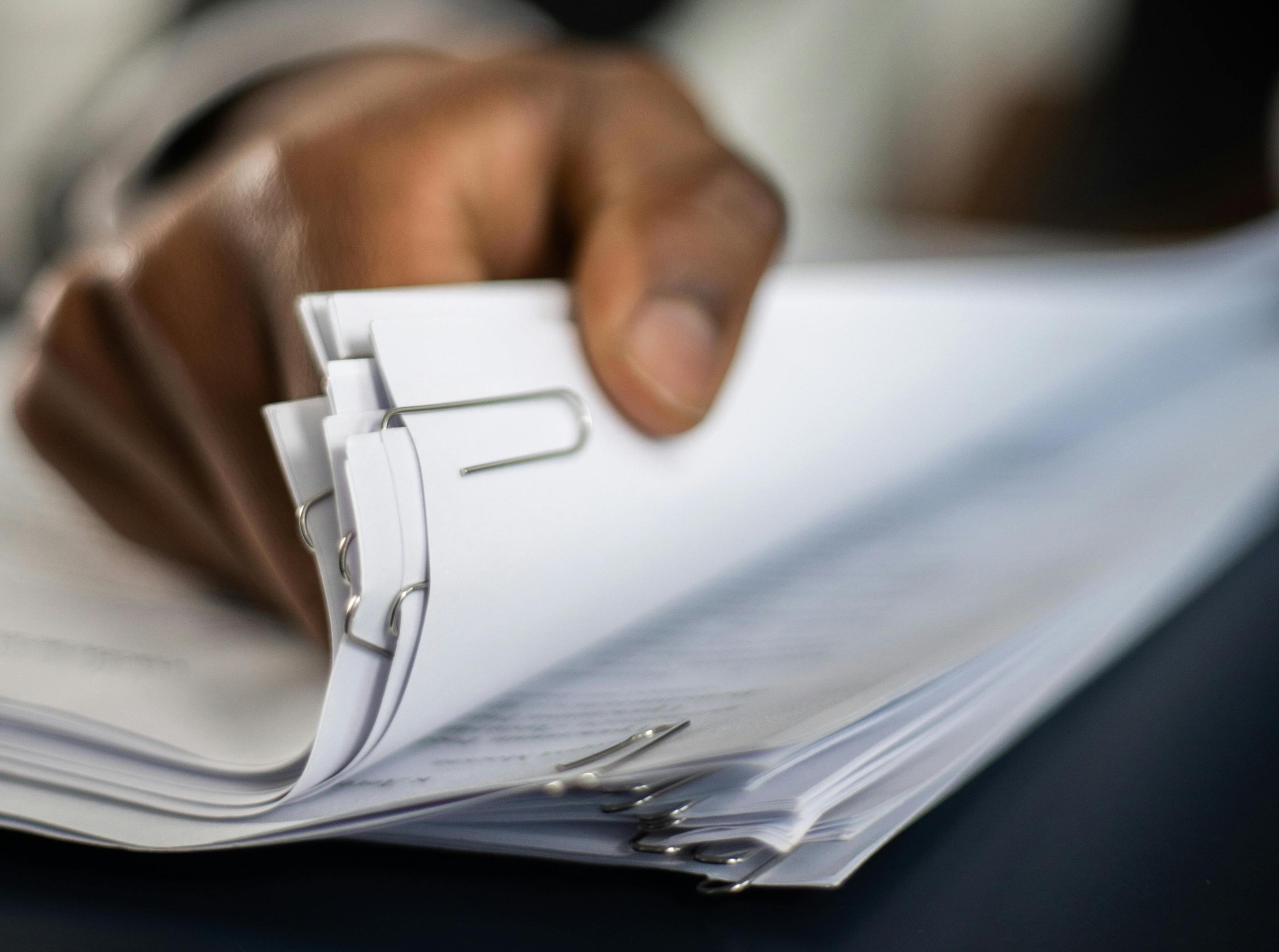 person looking at stack of official documents
