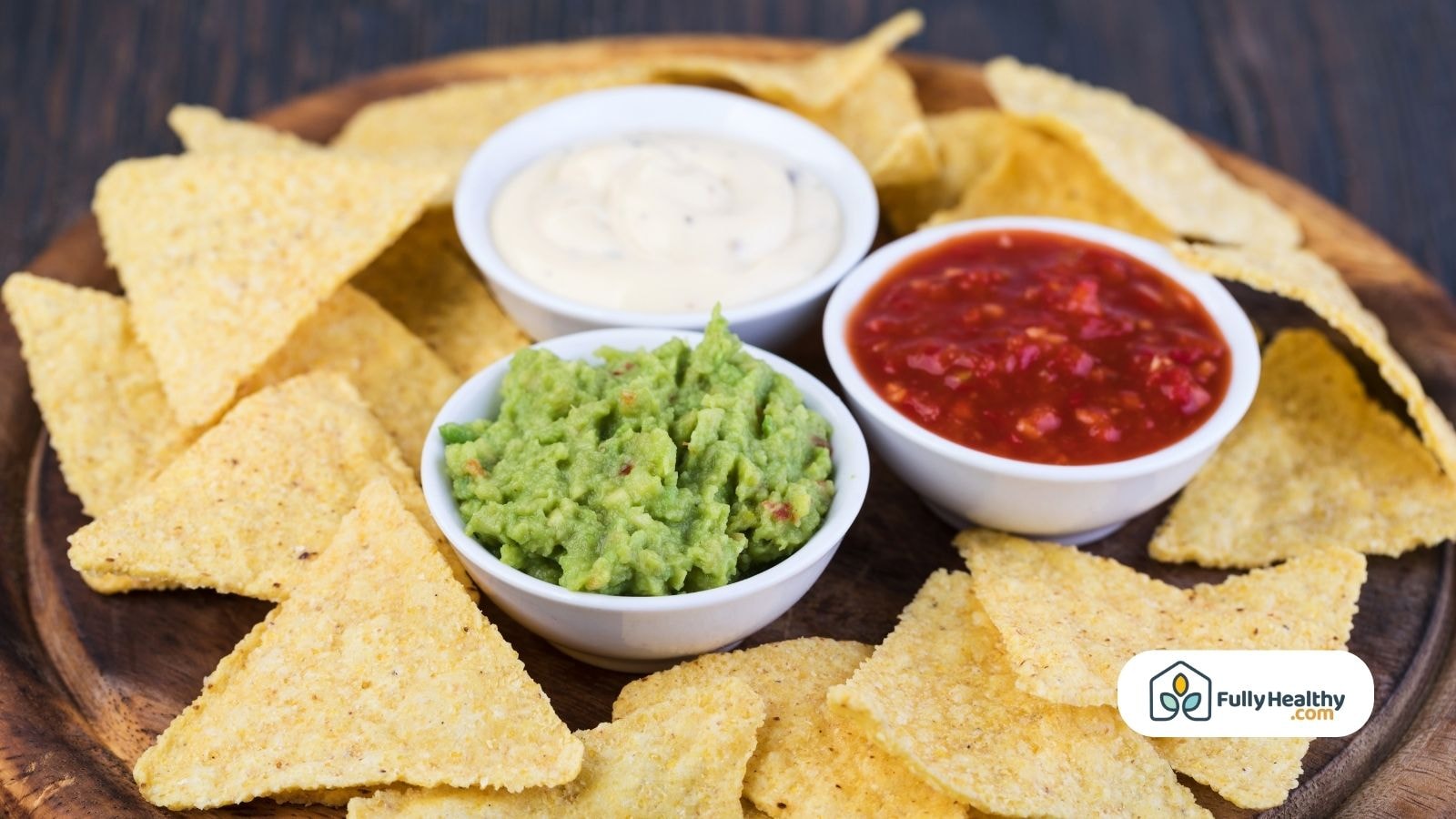 Tortilla chips with guacamole, salsa, and sour cream dipping bowls