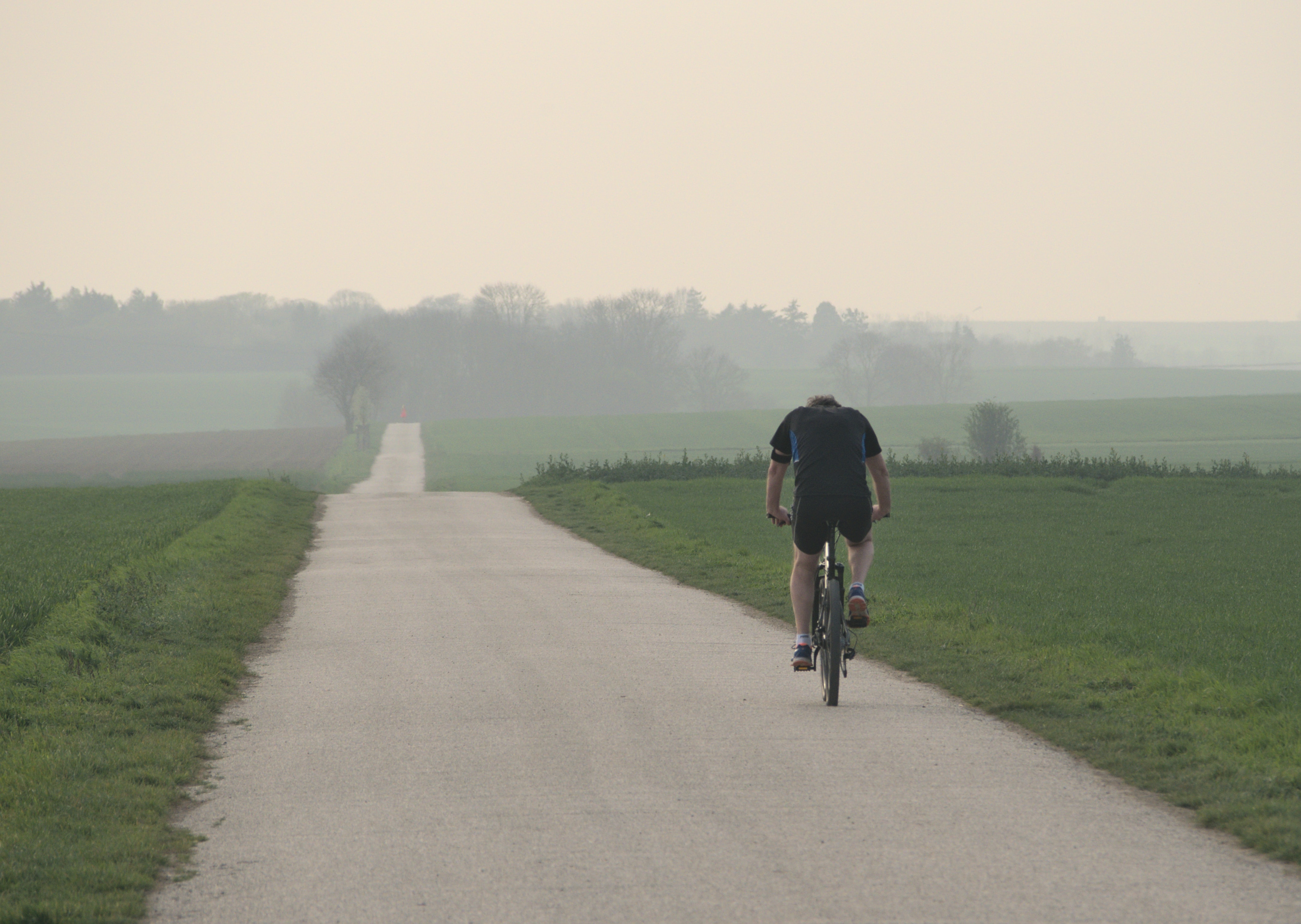 Homem andando de bicicleta numa estrada de terra