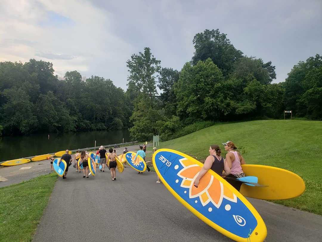 group carrying rental paddle boards