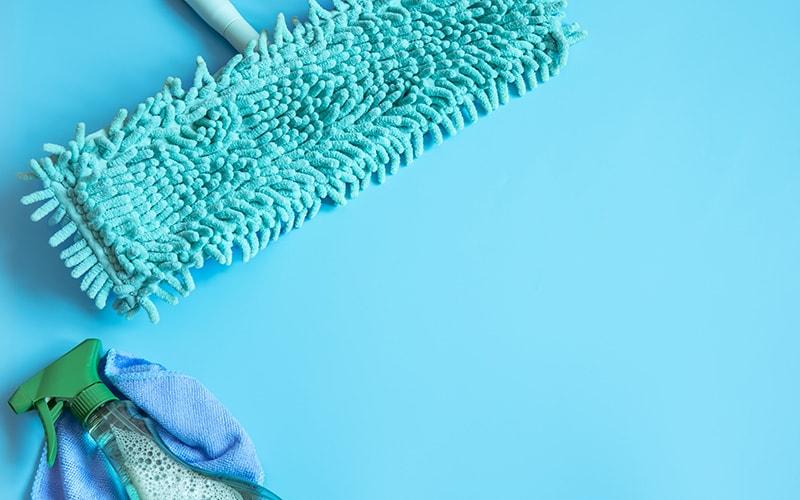 Blue Chenille dry mop next to cleaning supplies