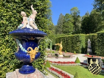 A picturesque Bavarian countryside scene showcases rolling hills adorned with lush greenery, leading up to the majestic distant Alps. This tranquil landscape evokes the charm of the region, often associated with the famous neuschwanstein castle and its enchanting surroundings.