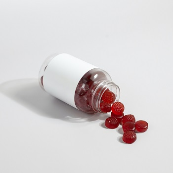 A person holding a bottle of 10mg CBD gummies with a label showing the serving size