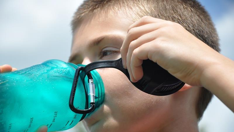 Boy drinking water from safe water bottle