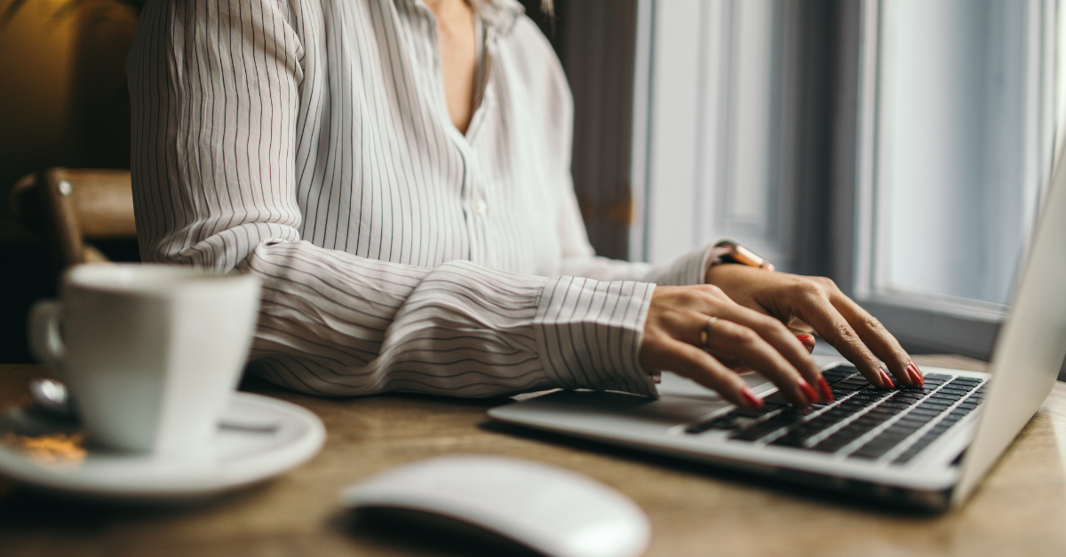 Person working on a laptop with a cup of coffee, highlighting the benefits of virtual bookkeeping for OnlyFans taxes and accounting.