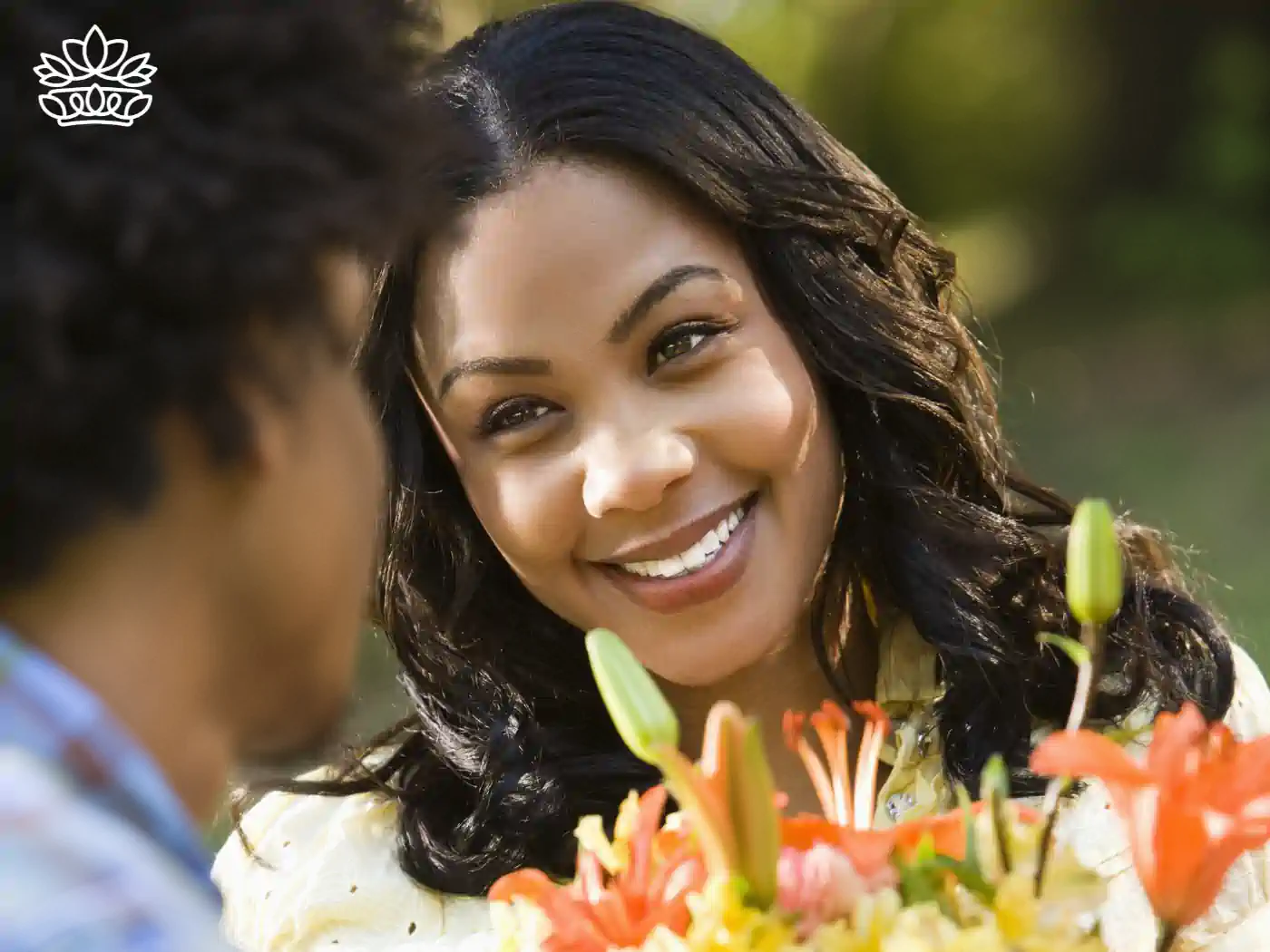 A woman smiling at a man who is holding a vibrant bouquet of lilies. Fabulous Flowers and Gifts. Flower Delivery to Cape Town Collection.