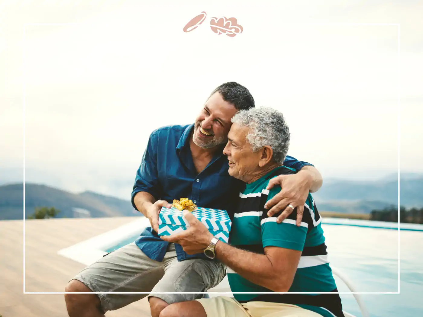 Man hugging an elderly man while giving him a gift - fabulous flowers and gifts