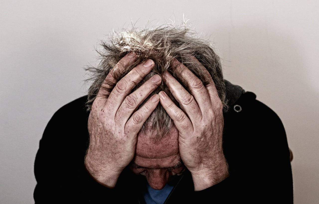 a man holding his head, representing rehab centers los angeles