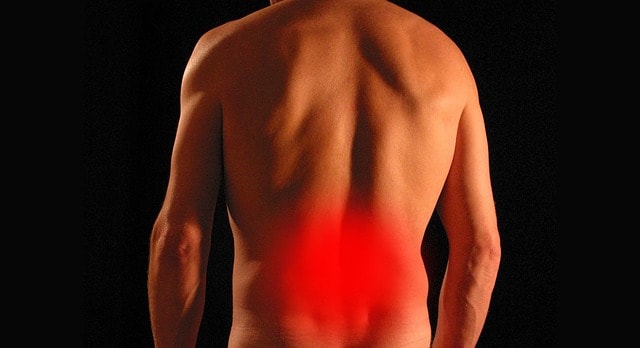 Rear view of a muscular man with lower back pain highlighted in red, representing myofascial pain syndrome, muscle tension, or lumbar discomfort.