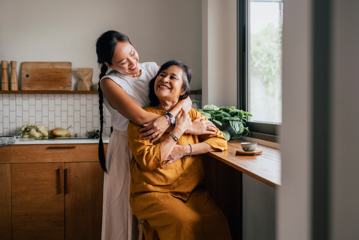 Asian American daughter hugging her grandmother. 