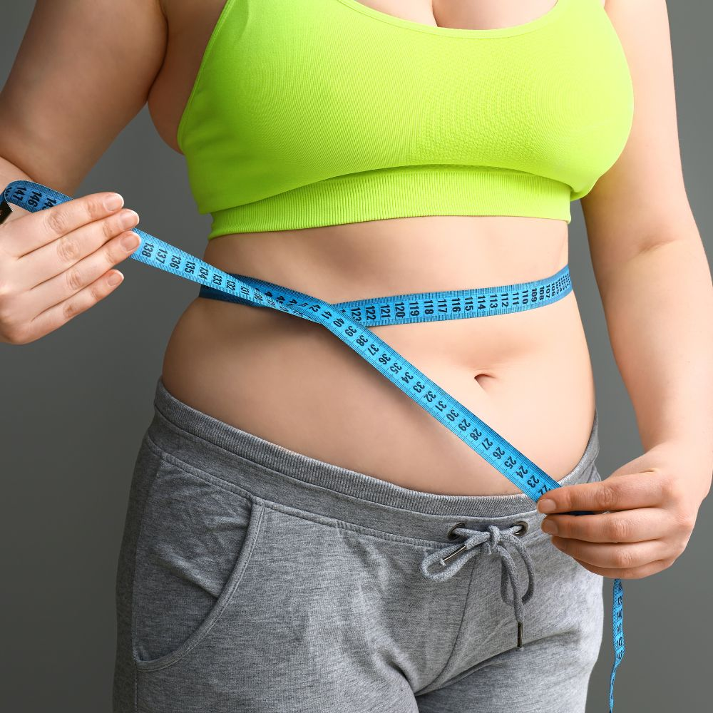 A person measuring their body weight reduction after successful weight loss journey
