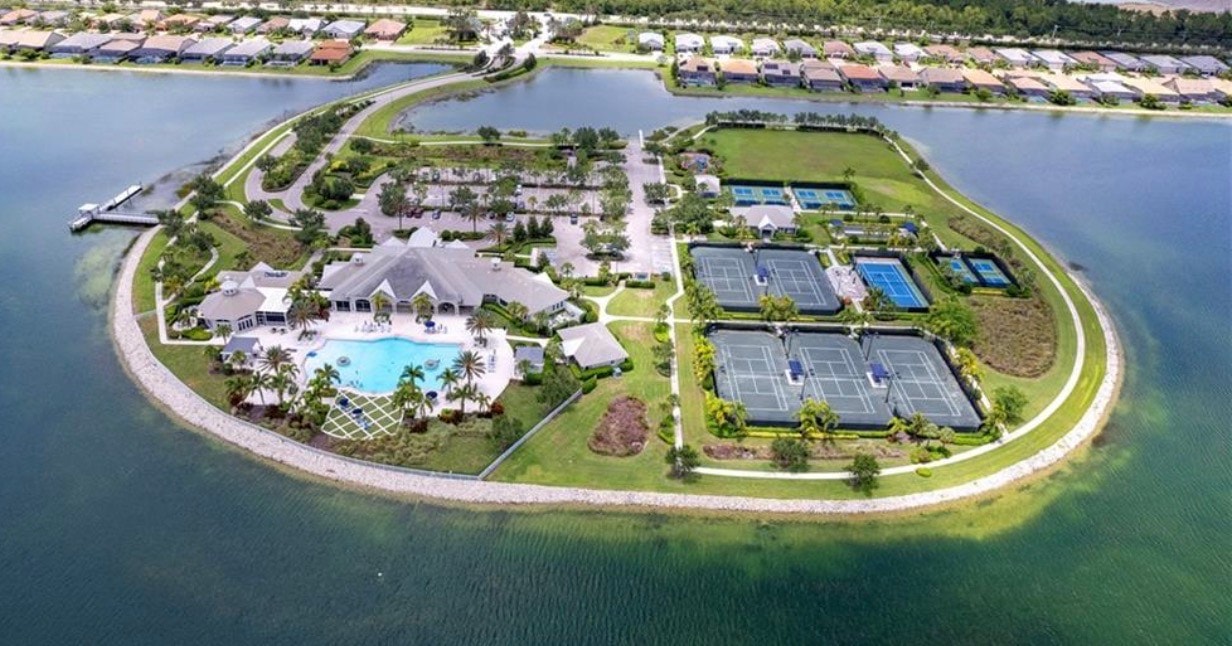 The image showcases tennis and pickleball courts nestled within a beautifully landscaped area, surrounded by nature preserves in the Corkscrew Shores community. This master-planned, gated community in Southwest Florida offers residents easy access to a variety of outdoor amenities, enhancing their active lifestyle.