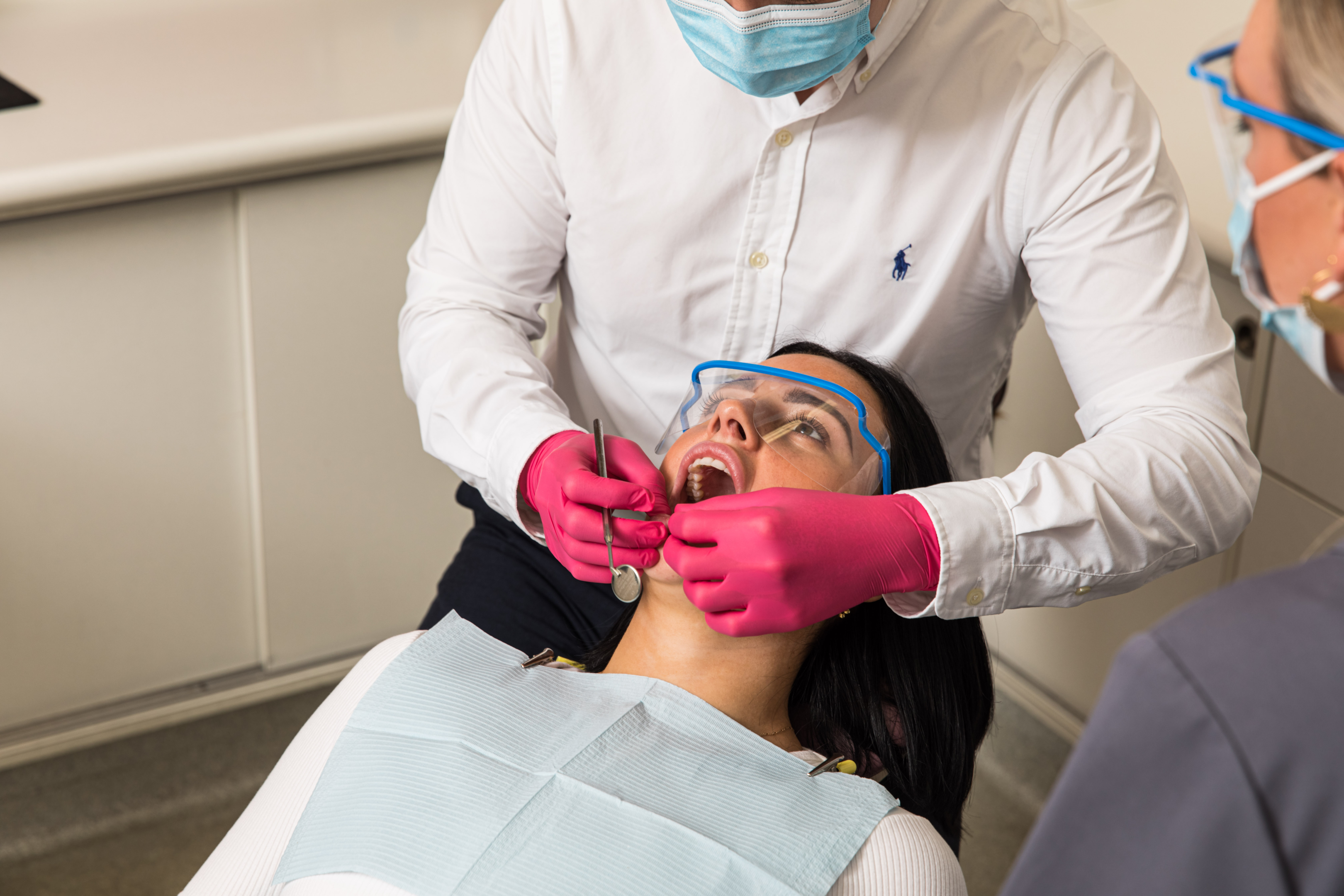 Dentist assisting a patient to wear invisible braces