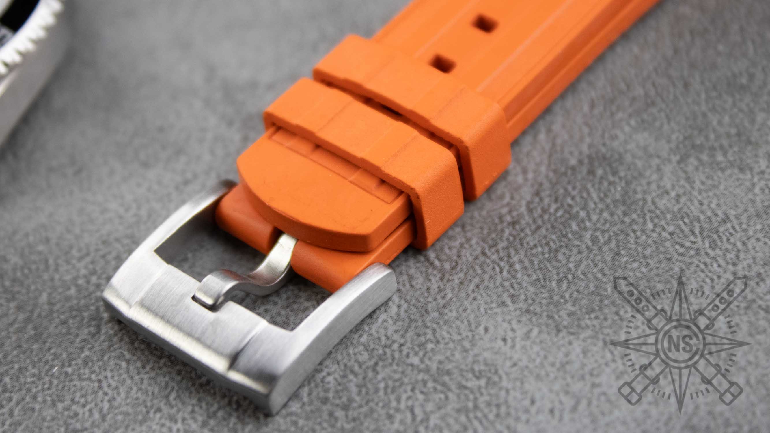 A selection of various orange rubber watch straps arranged aesthetically.