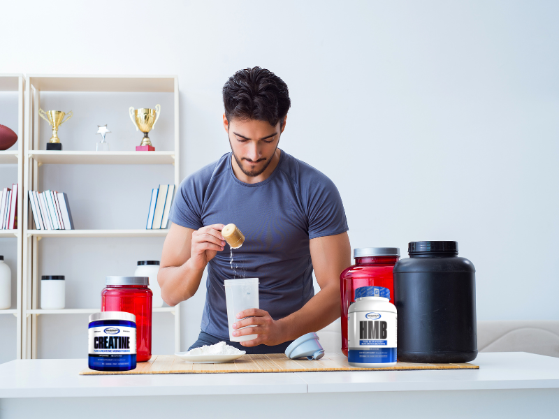 An image showing HMB and creatine supplements with athletes exercising.