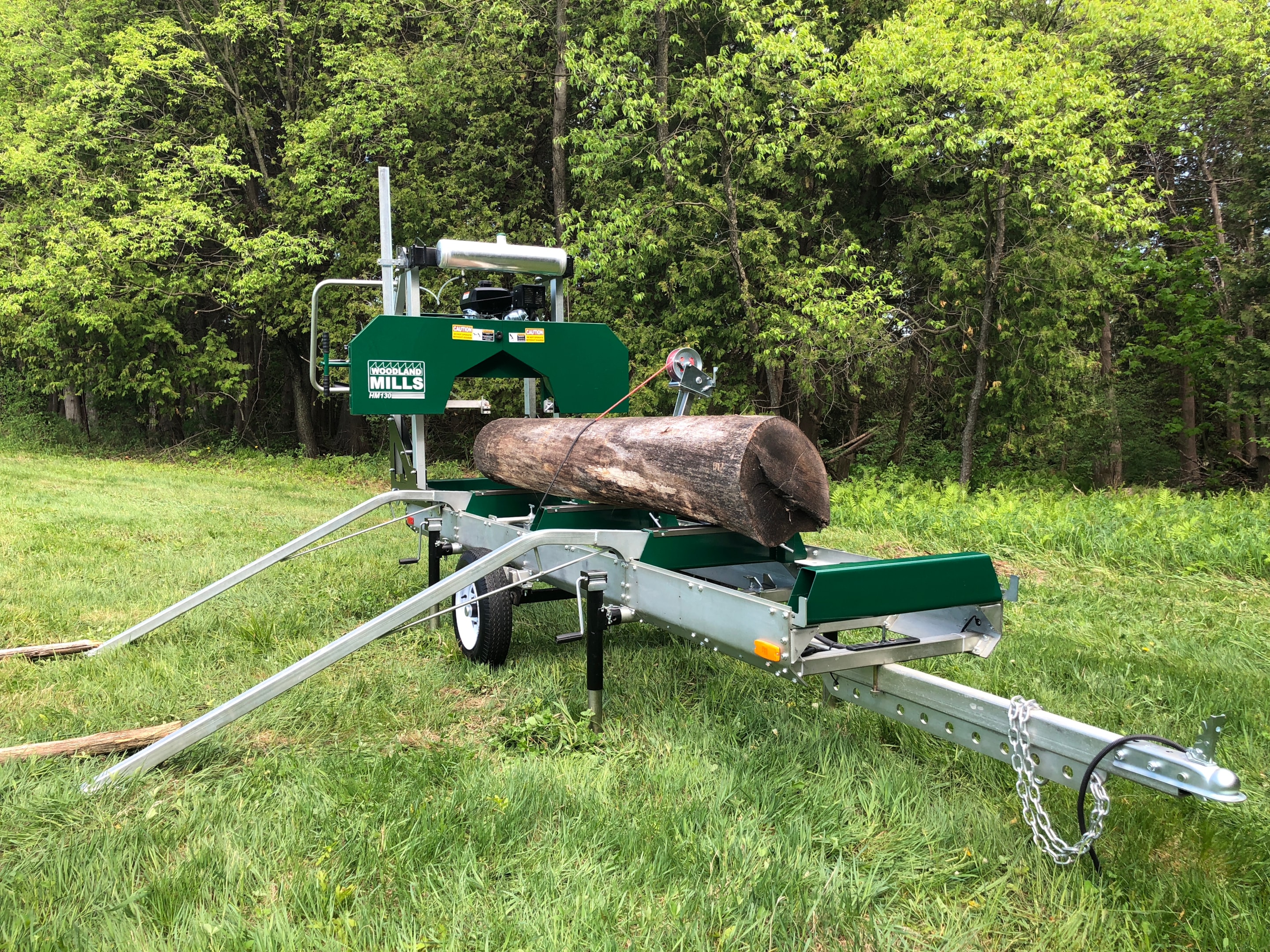 A portable sawmill with a ramp and winch kit, capable of handling logs of all sizes.