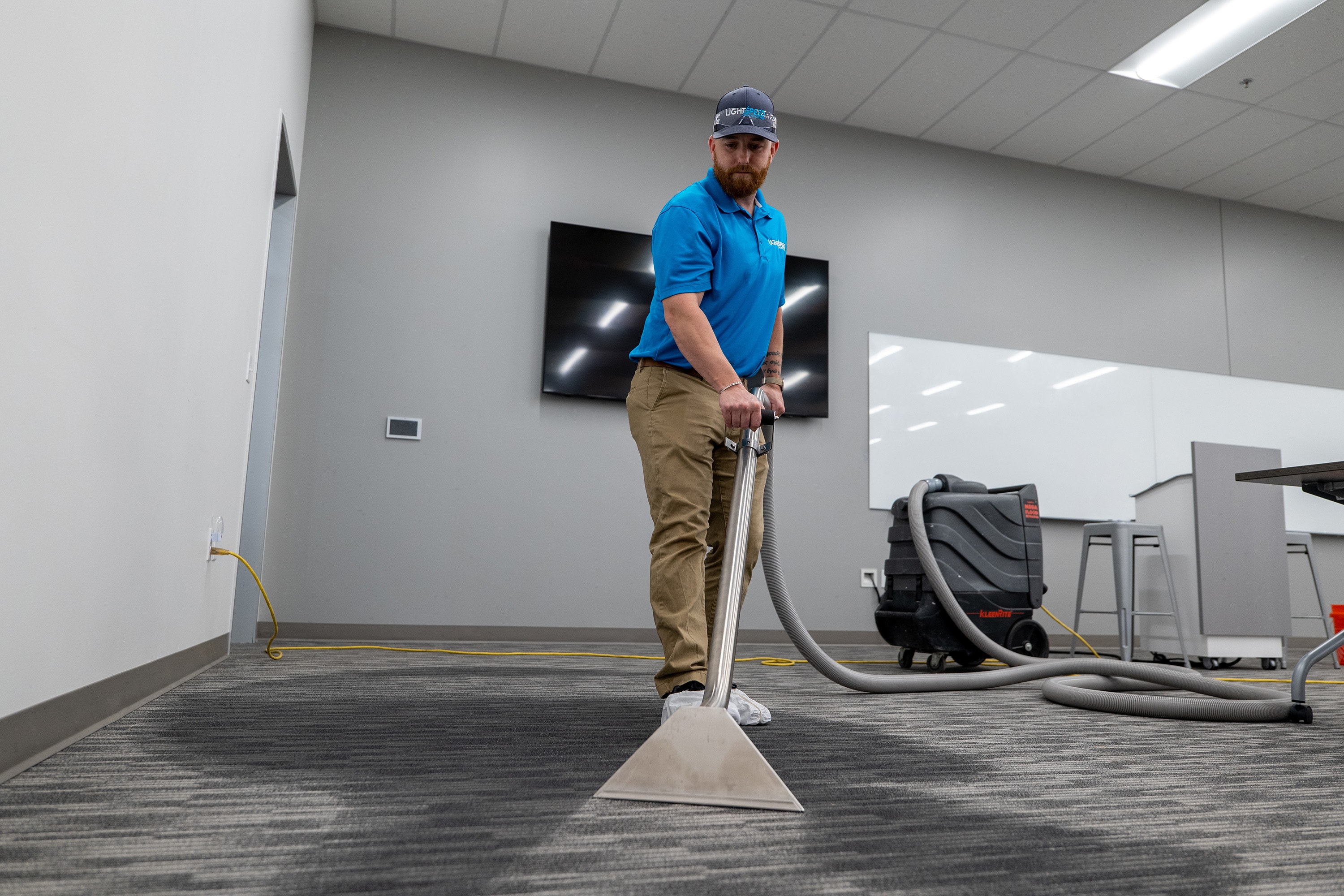The image depicts a portable water extraction unit positioned in a commercial building, with hoses extending into the structure to facilitate flood water removal. This scene highlights the urgent need for flood cleanup and restoration to prevent further damage and protect against potential mold growth and other hazards.