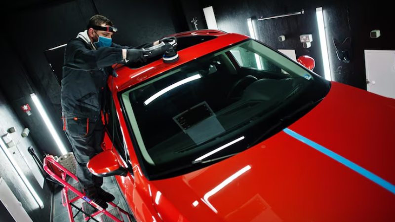 A mechanic removing bubbles from PPF coating