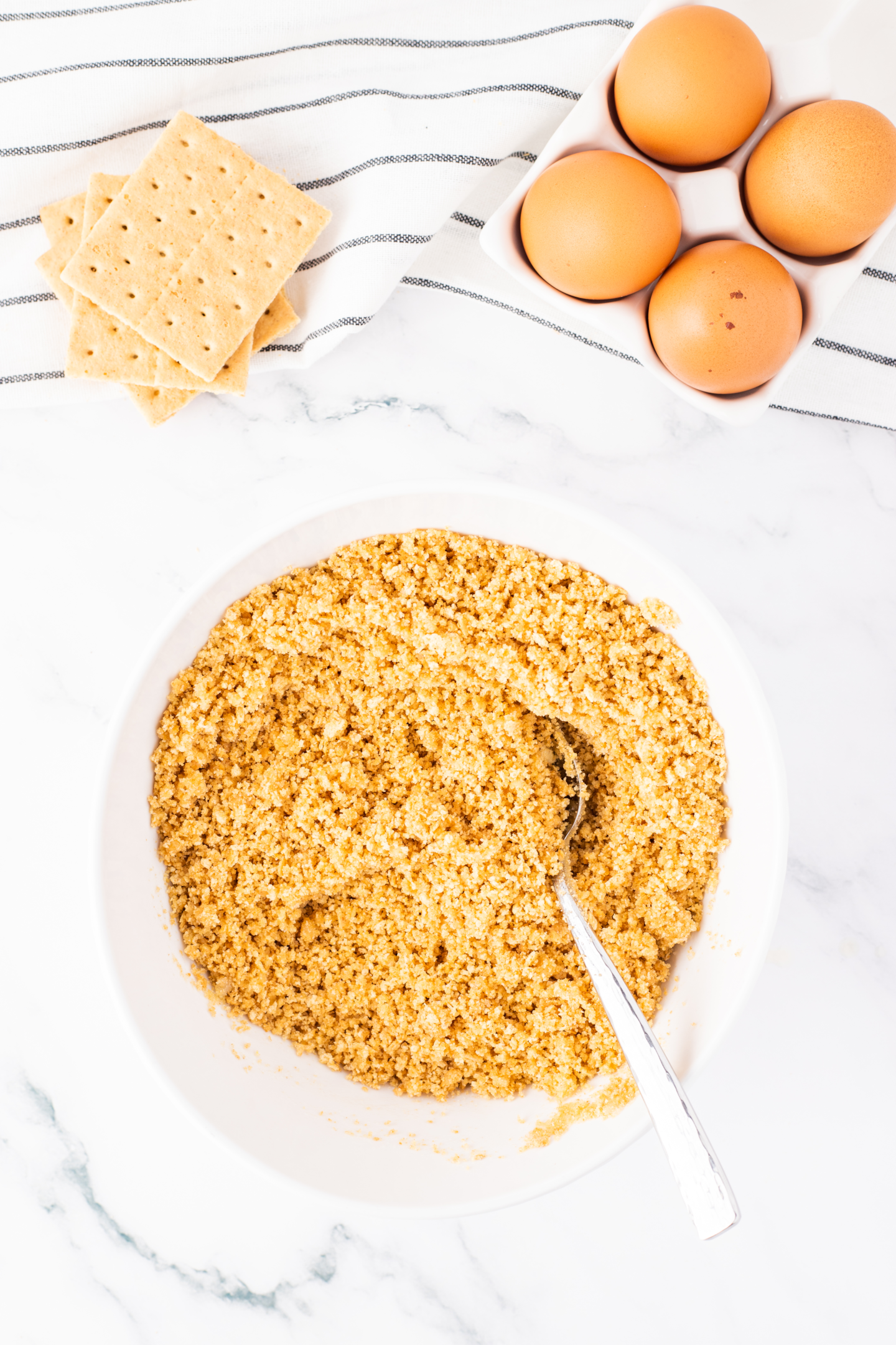 graham cracker crust mixture in a bowl with a spoon