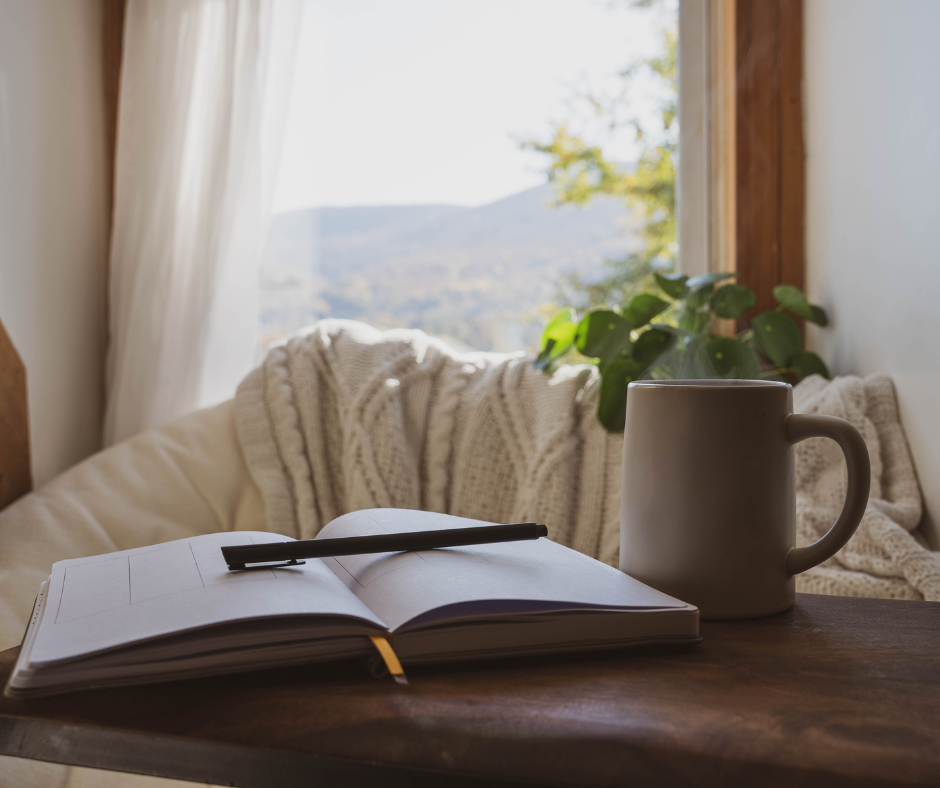 a notebook with coffee cup in front of a window