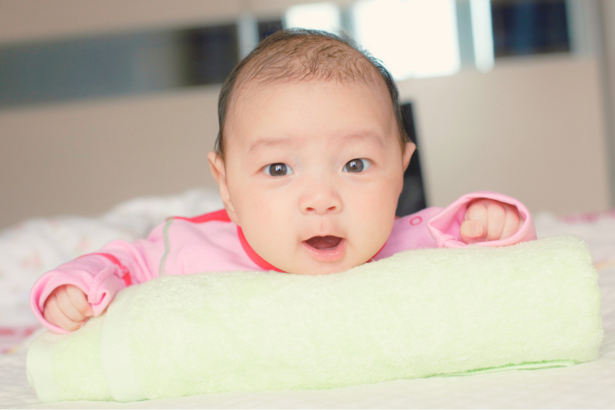 Baby doing tummy time. Poppyseed Play