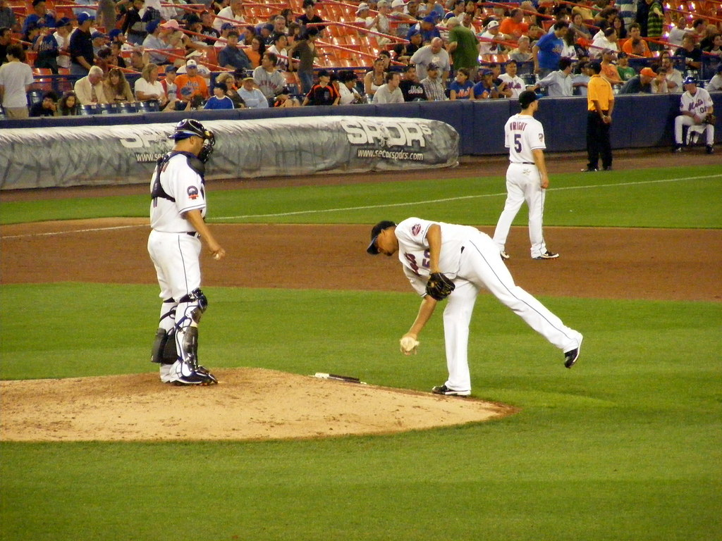 A baseball pitcher applying rosin to his hands on the pitcher's mound