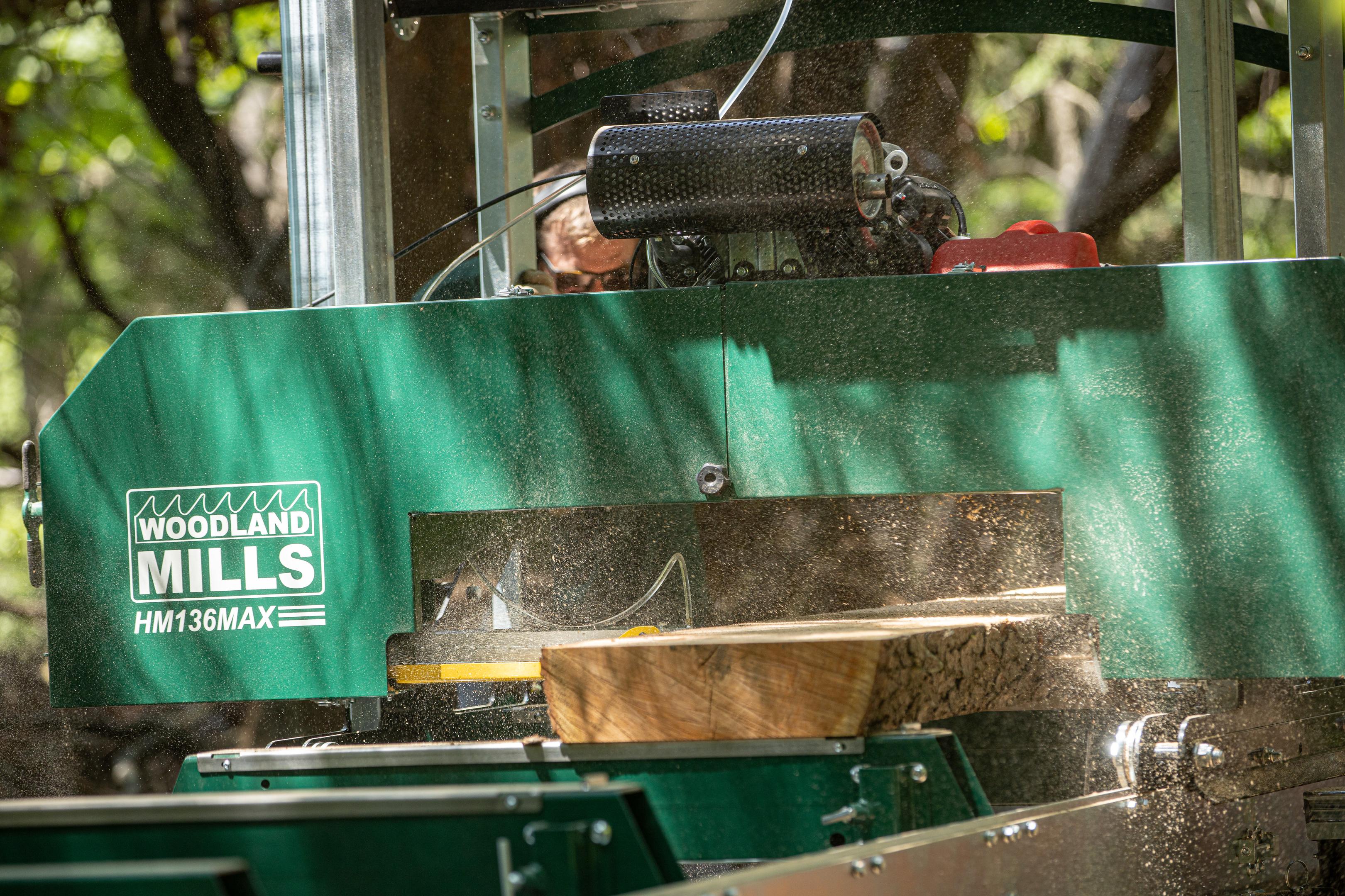 The sawhead of a Woodland Mills HM136MAX Portable Sawmill cutting through a log. 