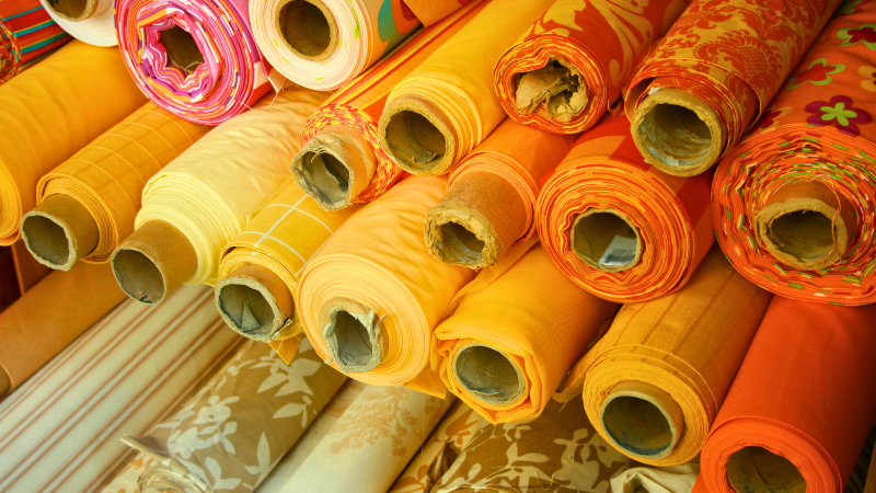 Many rolls of fabric are stacked together