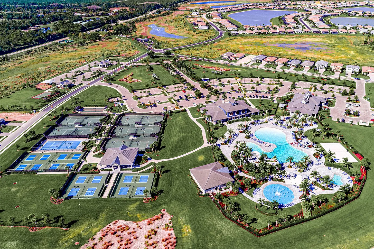 The image depicts a serene natural wetlands area in Estero, Florida, featuring lush native vegetation and well-maintained walking paths that invite residents to explore the beauty of the outdoors. This tranquil setting is part of a master-planned community, offering resort-style amenities that enhance the lifestyle of its residents.