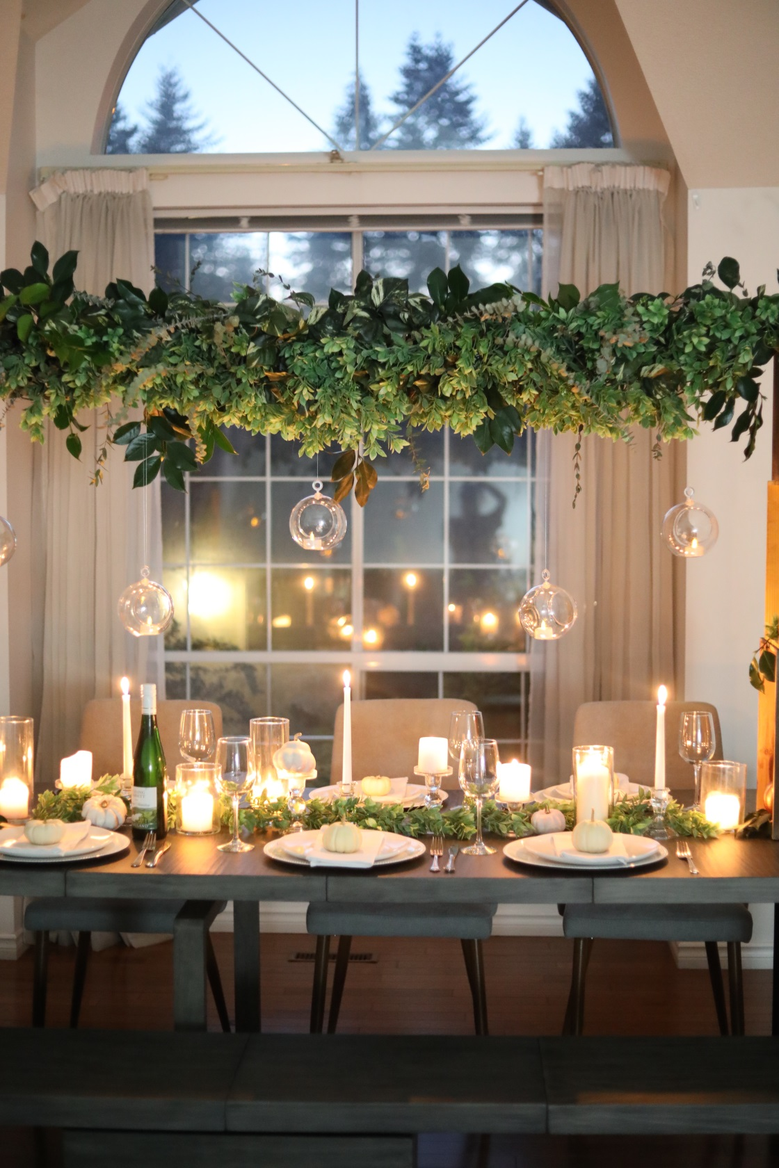 A dining table decorated with a hanging wreath.